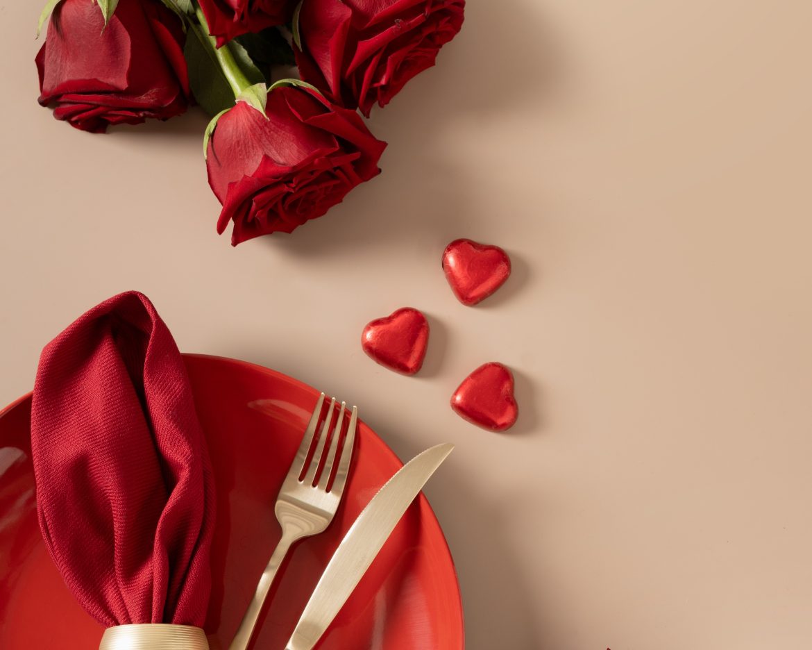 Valentine's day dinner with red plate, romantic gift and red roses.
