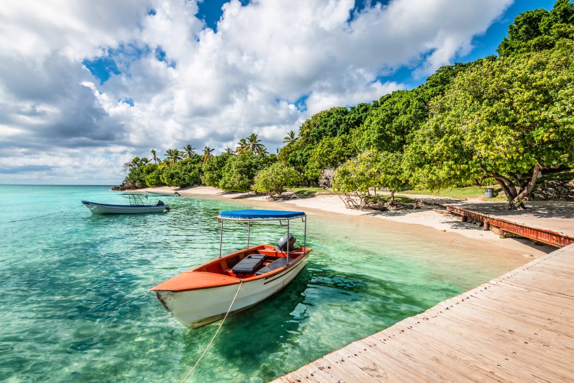 Petit bateau à moteur amarré à la jetée et sur la plage de l'île de Cayo Levantado, dans la baie de Samana, en République dominicaine.