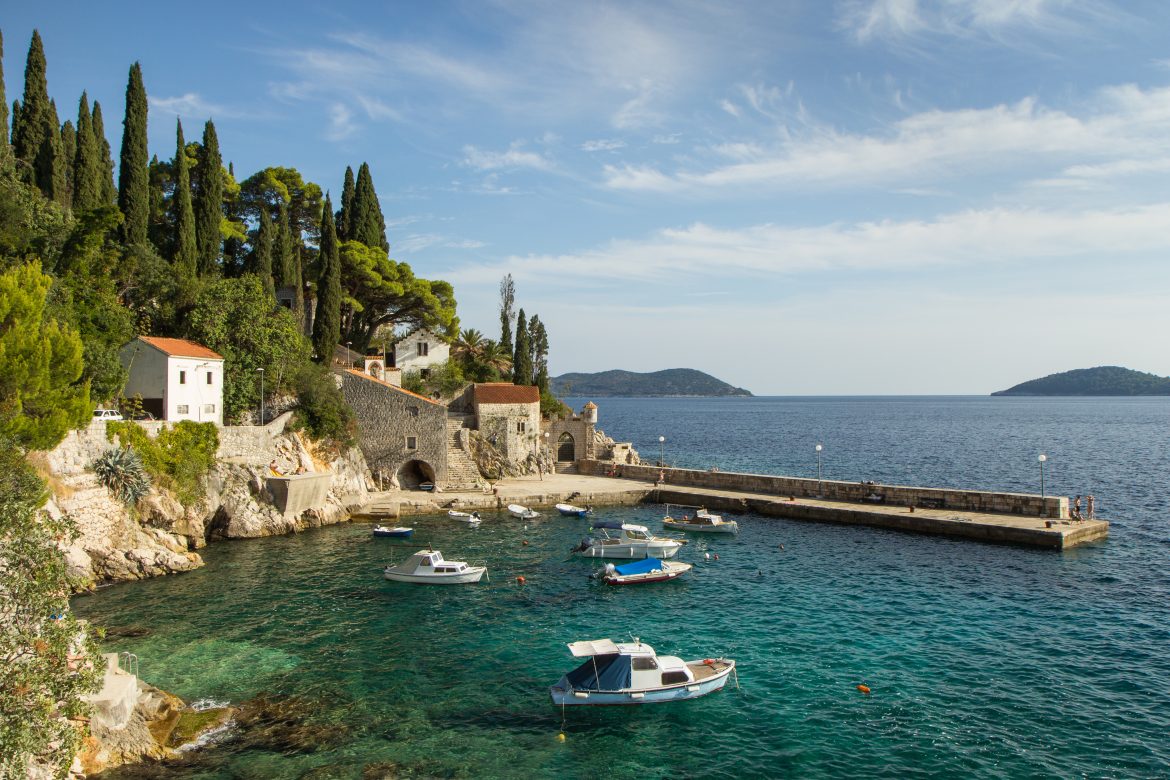 Vue pittoresque d'un port avec quelques bateaux et de vieux bâtiments dans la petite ville de Trsteno en Croatie.
