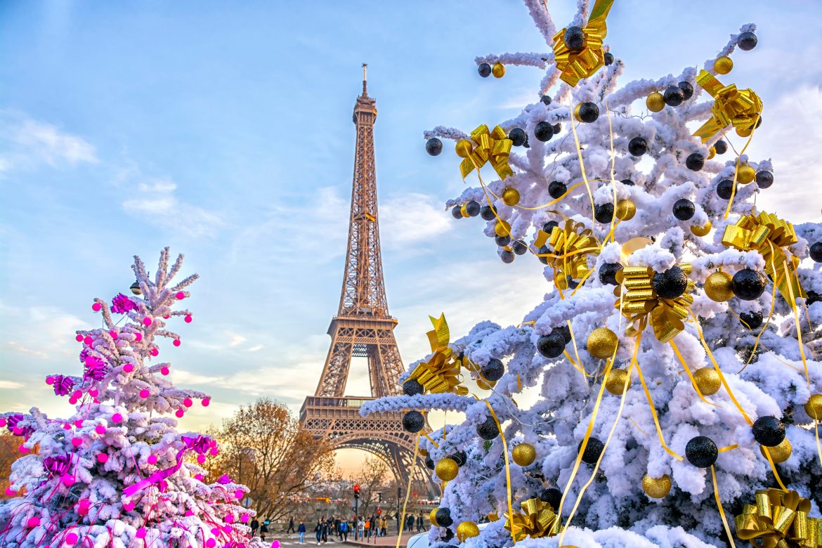 Eiffel Tower is the main attraction of Paris on the background of decorated Christmas trees in December. Travel Greeting Card with Christmas in Paris, France La tour Eiffel est l'attraction principale de Paris, avec en arrière-plan les sapins de Noël décorés en décembre. Carte de vœux de voyage avec Noël à Paris, France