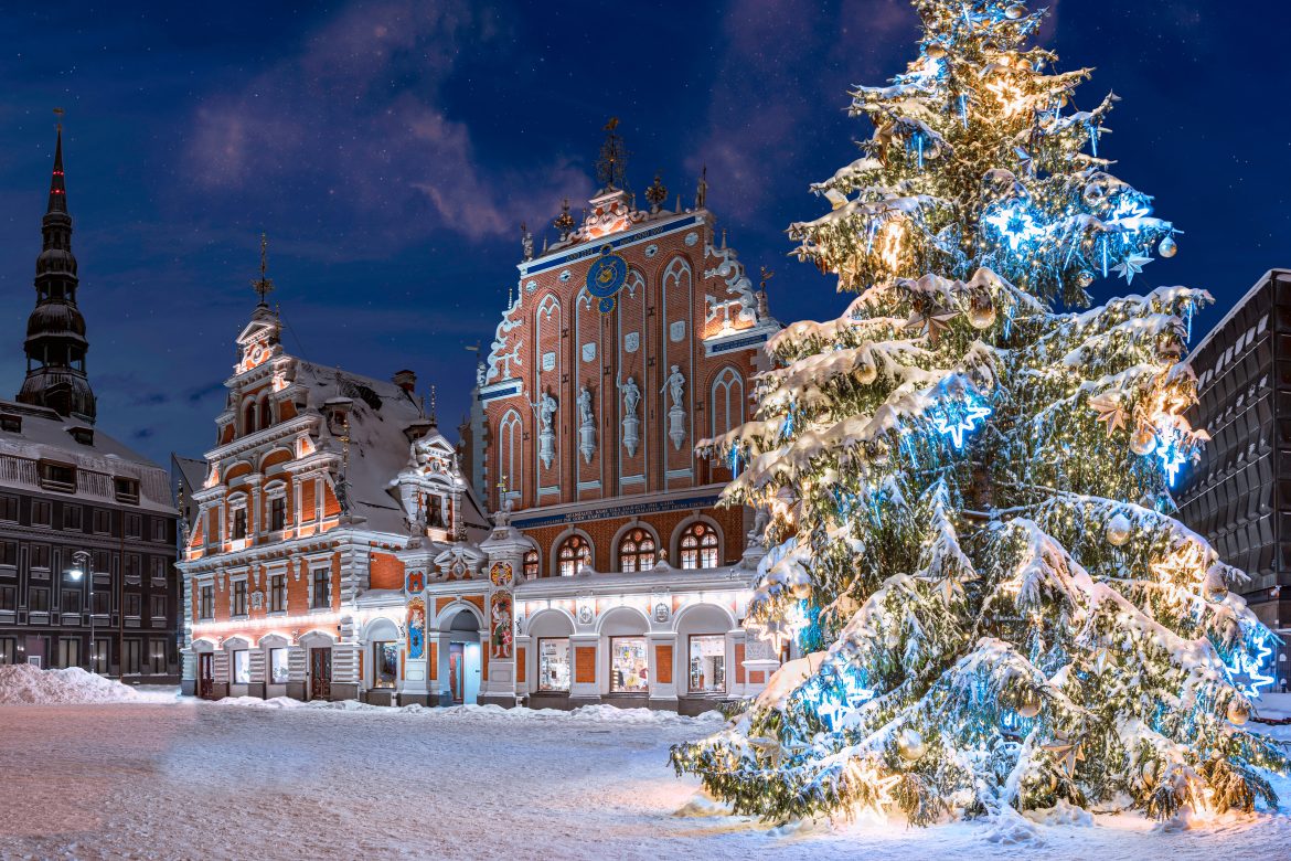 Sapin de Noël illuminé la nuit. Place de l'Hôtel de Ville avec la Maison des Têtes Noires et le sapin de Noël en hiver, vieille ville de Riga, Lettonie. Carte postale de Noël de Riga