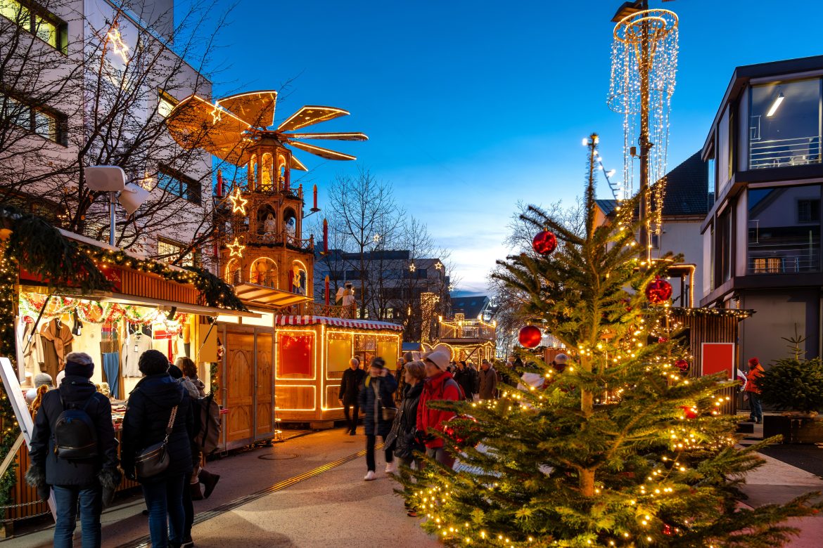 Ambiance pré-Noël à Bregenz avec ses étals de marché, son sapin de Noël et ses visiteurs au crépuscule