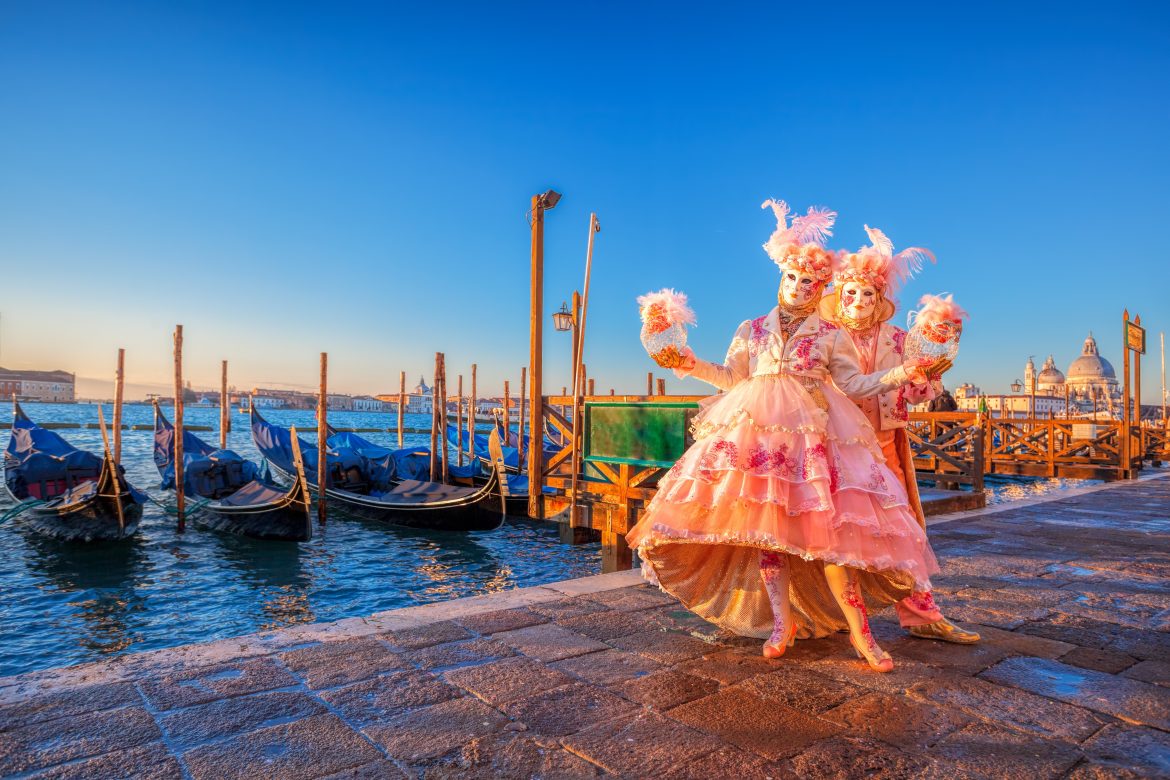 Famous carnival masks against gondolas in Venice, Italy Célèbre Carnaval à Venise, face à des gondoles à Venise, en Italie