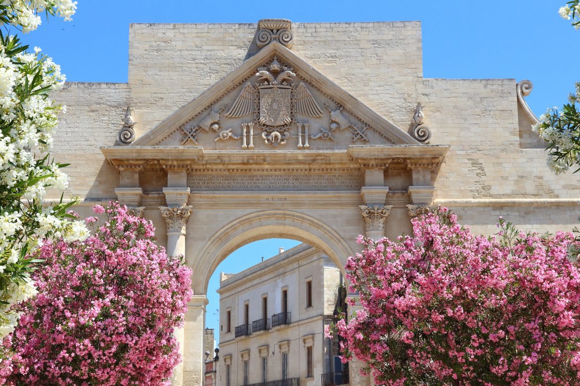 Lecce, Italie - ville de la péninsule du Salento. Fleurs de lauriers-roses et arc de triomphe de Porta Napoli.